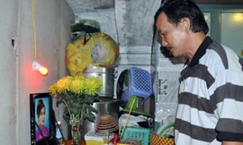 Ông Minh (bố chị Ngân) lặng người bên bàn thờ con gái.