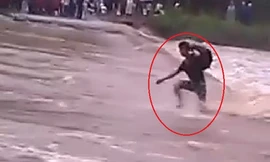 Thanh niên liều mạng chạy qua dòng nước lũ chảy xiết