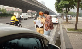 Tổ công tác nhắc nhở xử lý các trường hợp dừng đỗ xe vi phạm. Ảnh: Thanh Hà