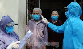 Cán bộ y tế đến từng nhà dân ở thôn Hạ Lôi, Mê Linh, Hà Nội đo thân nhiệt và ghi nhận tình hình sức khỏe từng người dân. Ảnh: Mạnh Thắng