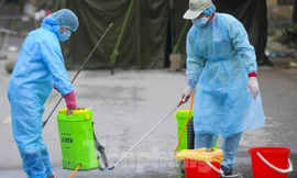 Nhân viên y tế phun thuốc khử khuẩn môi trường tại ổ dịch Hạ Lôi, Mê Linh, Hà Nội. Ảnh: Mạnh Thắng