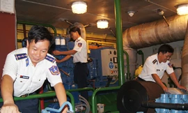 Trung úy Thạnh (trái) kiểm tra máy trước khi tàu khởi hành Ảnh: Ng.Minh