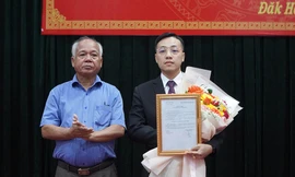 Phó Bí thư Thường trực Tỉnh ủy Kon Tum (trái) trao quyết định và tặng hoa chúc mừng tân Phó Bí thư Huyện ủy Đăk Hà