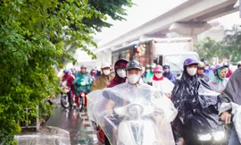 Người dân di chuyển khó khăn trong cơn mưa kéo dài đầu giờ sáng tại Hà Nội.