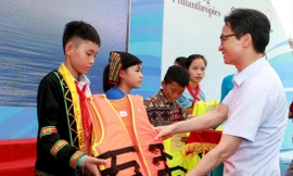 Phó Thủ tướng Vũ Đức Đam - Chủ tịch Ủy ban Quốc gia về trẻ em tặng áo phao cho học sinh dân tộc thiểu số. Ảnh: Mạnh Dũng 
