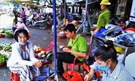 Đôi vợ chồng hành nghề gần chợ xóm Chiếu, quận  4. Ảnh: Trần Nguyễn Anh 