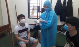 Trung úy Ngô Thị Vân Anh kiểm tra, ghi chép tình hình sức khỏe công dân ở khu cách ly. ẢNH: PV 