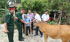 Trung tướng Nguyễn Đức Soát, Chủ tịch Hội Hỗ trợ khắc phục hậu quả bom mìn Việt Nam, tặng bò cho nạn nhân bom mìn tại huyện Bố Trạch, tỉnh Quảng Bình. Ảnh: L.A 
