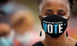 Một cử tri da màu Mỹ đeo khẩu trang có dòng chữ: “Che mặt nhưng không im lặng. Bầu cử” Ảnh: Getty 