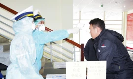 Kiểm tra thân nhiệt người nhập cảnh vào Việt Nam qua cửa khẩu Ma Lù Thàng (Lai Châu). Ảnh: PV 