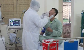 Trung tá, bác sĩ Nguyễn Đức Đồng thăm khám cho bệnh nhân nghi mắc COVID-19 Ảnh: PV 