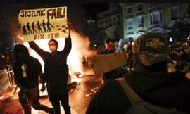  Một người biểu tình Mỹ giương tấm biển có khẩu hiệu “Systemic Fail” (Thất bại hệ thống) gần Nhà Trắng ngày 31/5 ảnh: AP 