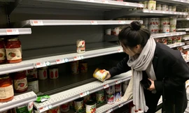 Một khách hàng đang chọn mua hộp sốt cà chua tại cửa hàng tạp hóa Whole Food ở thành phố New York. Ảnh: Alex Fang