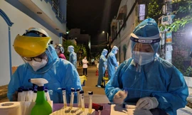 Nhân viên y tế lấy mẫu xét nghiệm trong khu vực phong tỏa khu dân cư Nam Long (ảnh: HCDC)