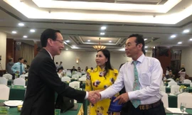 Phó chủ tịch Thường trực UBND TPHCM Lê Thanh Liêm (trái) trò chuyện cùng kiều bào