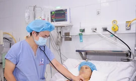 Bác sĩ khám cho bệnh nhân sau phẫu thuật