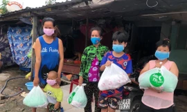 Chị Trần Thị Thu Trúc (bìa trái) vui mừng vì nhận được phần thực phẩm thiết yếu