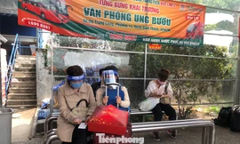 Hành khách đội mũ chống giọt bắn chờ xe khách