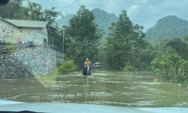 Lực lượng chức năng cảnh báo người dân qua lại cầu ngầm, nơi nước xiết chảy qua. 