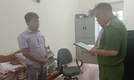 Đối tượng Nông Văn Thuận (bìa trái) nghe quyết định khởi tố bị can. Ảnh: CB