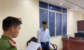 Ông Nguyễn Trọng Phùng (bìa phải) nghe lệnh khởi tố bị can .Ảnh: CB