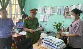 Lực lượng chức năng đọc quyết định khởi tố bị can, bắt tạm giam đối tượng Nông Thị Quỳnh Lan (bìa phải). Ảnh: TL