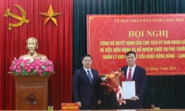 Ông Vũ Quang Khánh (bìa phải) nhận quyết định, hoa chúc mừng. Ảnh: Duy Chiến 