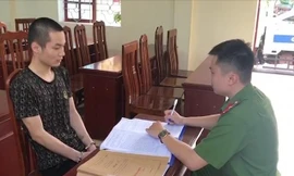 Đối tượng Hoàng Văn Tuấn (bìa trái) tại cơ quan công an -Ảnh: H.T