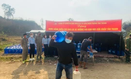 Lái xe chở nông sản vui mừng được phát bình nước sạch miễn phí -Ảnh: Duy Chiến 