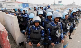 Cảnh sát Ấn Độ đứng gác cạnh rào chắn được dựng lên trên đường quốc lộ để ngăn chặn nông dân tiến về thủ đô New Delhi ngày 13/2. (Ảnh: Reuters)