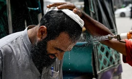 Một người đàn ông Pakistan được phun nước vào mặt cho đỡ nóng. (Ảnh: Getty)