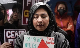 Một phụ nữ cầm tấm biển có hình ảnh dưa hấu khi tham gia cuộc biểu tình ở Los Angeles tháng 11/2023. (Ảnh: AP)