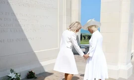 Đệ nhất phu nhân Pháp cố nắm tay Hoàng hậu Anh. (Ảnh: Daily Mail)