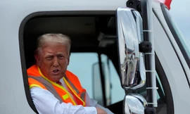 Ông Trump ngồi trên chiếc xe chở rác màu trắng in tên ông. (Ảnh: AP)