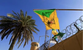 Một thành viên của lực lượng bán quân sự Hashd al-Shaabi giương cờ của nhóm dân quân Kataib Hezbollah trong cuộc biểu tình bên ngoài Đại sứ quán Mỹ ở Baghdad ngày 31/12/2019. (Ảnh: Reuters)