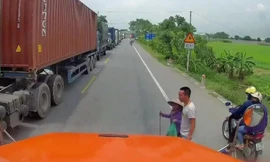 Tài xế container dừng xe dẫn bà lão sang đường