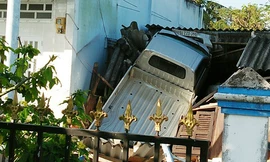 Xe tải 'bay' qua ngọn cây, rơi xuống nóc nhà