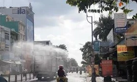 Chủ tiệm rửa xe xịt nước làm mát người đi đường giữa trưa nắng