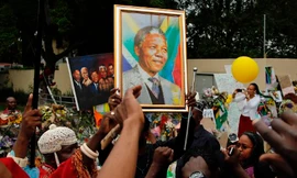 Người dân hát bên ngoài nhà cố tổng thống Nam Phi Nelson Mandela tại Johannesburg, hôm qua, mùng 9/12.