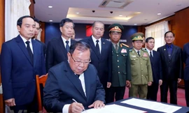 Tổng Bí thư, Chủ tịch nước Lào Bounnhang Vorachith ghi sổ tang tại lễ viếng Chủ tịch nước Trần Đại Quang. (Ảnh: Phạm Kiên/Vietnam+)
