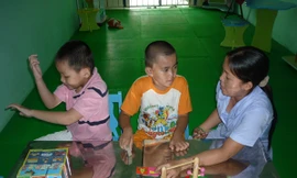 Cô giáo ở trường dạy trẻ chuyên biệt Khai Trí đang dạy 2 trẻ bị tự kỷ. Ảnh: L.N