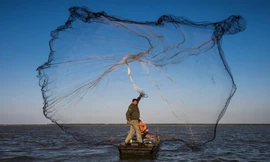 Một ngư dân quăng lưới đánh bắt ở tỉnh Giang Tô, Trung Quốc. (Ảnh: Xinhua)