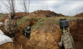 Lính Ukraine đứng gần một tên lửa chống tăng Javelin trong chiến hào ở Donetsk ngày 18/4. (Ảnh: Reuters)