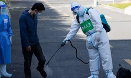 Một người dân được khử trùng sau khi rời khu cách ly tập trung ở Thượng Hải ngày 9/4. (Ảnh: AP)