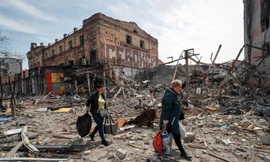 Người dân mang đồ rời khỏi thành phố Mariupol của Ukraine ngày 10/4. (Ảnh: Reuters)