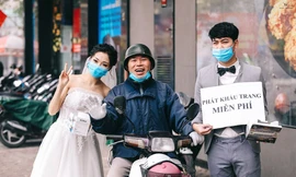 Chú rể Nghiêm Đình Đăng và cô dâu Phạm Ngọc Vy tặng khẩu trang miễn phí cho người dân Hà Nội. ảnh: Windy Wedding.