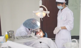 Bác sĩ khám răng cho bệnh nhân. Ảnh T.Hà