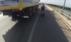 Cô gái liều mạng “nấp hông” theo xe tải để tránh nắng