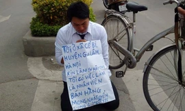 Nguyễn Việt Hải quỳ trước cổng Đài truyền hình với tấm biểu ngữ xin việc.