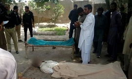 Cảnh sát đứng cạnh thi thể một phụ nữ và người nghi là bạn trai bị cha, anh trai và chồng của cô treo cổ ở làng Chak 56, gần thành phố Multan, Pakistan, ngày 15/9. Ảnh: AFP.